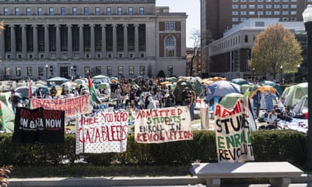 protest signs and tents with grand columned building beyond
