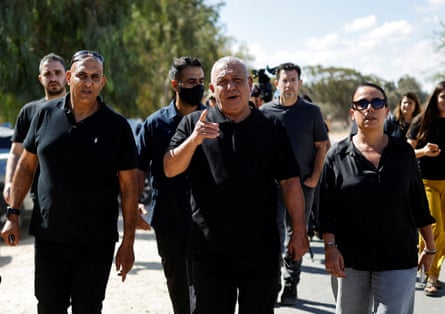 Gadi Eisenkot, flanked by advisers, points at the camera while walking down a road.