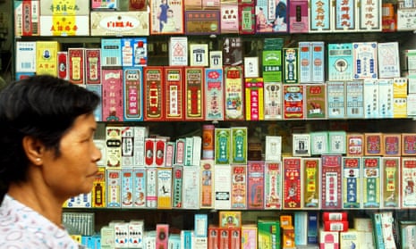 A pedestrian walks past a display stacked with Chinese medicine packages in Hong Kong
