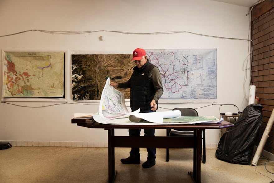 Buzz Cobell, director of fish and wildlife on the Blackfeet Nation, looks over historical and current maps of the reservation.
