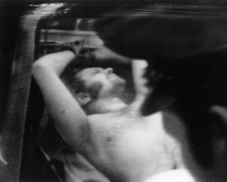 A topless man being taken away