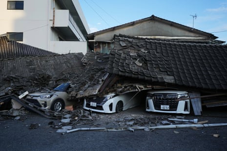 Three cars crushed under collapsed buildings.