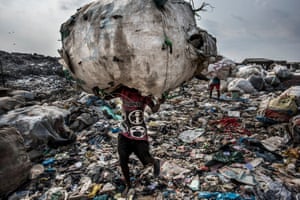 Environment – stories, first prize. A man carries a huge bag of bottles collected for recycling at the Olusosun landfill site in Lagos, Nigeria