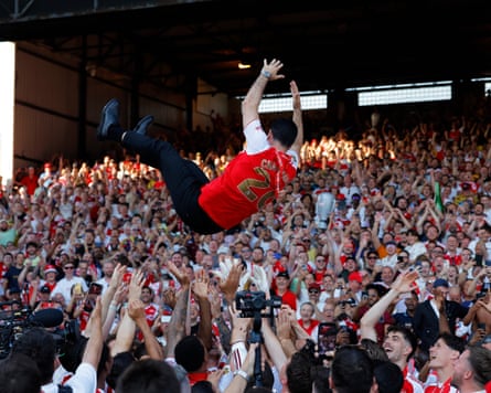 Arsenal's players throw their manager Mikel Arteta into the air, in front of their fans at Selhurst Park, while celebrating their Premier League title win.