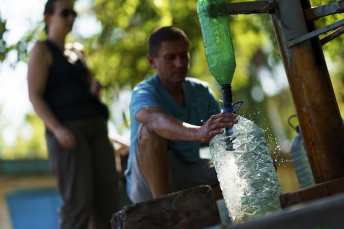 Residents gather to pump water from a well outside an apartment complex in Sloviansk.