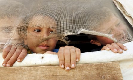Syrian children look out from their tent in Lebanon