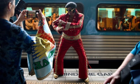 Alfred Vaz (centro) posa para fotografías vestido como Elvis Presley antes de la salida del Elvis Express con destino a Parkes, en la Estación Central de Sydney, el jueves 11 de enero de 2024.