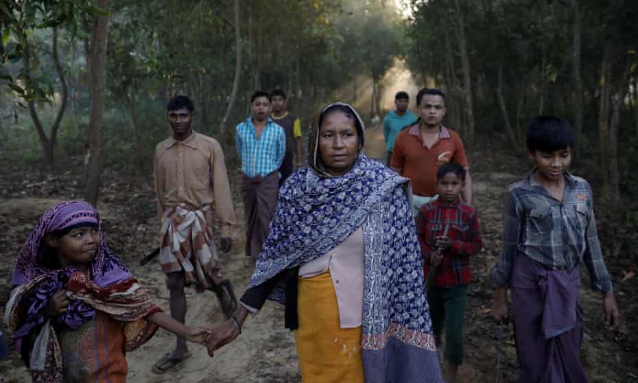 A Rohingya refugee walks with her daughter to cut firewood near the Palongkhali refugee camp in Bangladesh