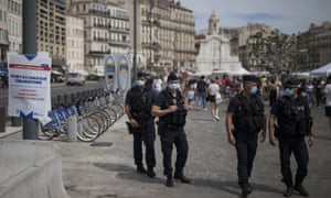 French riot police officers helping to enforce the wearing face masks in Marseille.