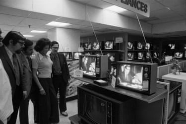 People watch televisions in a department store.
