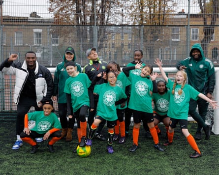 Girls from Dulwich Village Football Club pose for a team photo with coaches during a tournament hosted by the Celtic FC Foundation in Brixton.