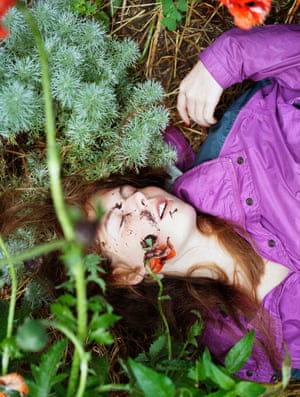 a girl with eyes closed lying in hay