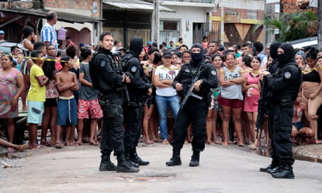 Policemen guard a site where, according to local media, an armed group entered and opened fire at a bar, killing 11, in Belem, Para state, Brazil.