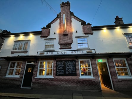 The exterior of a brick and rendered pub at dusk