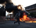 Protesting students throw items onto burning rubbing bins, as part of ongoing student blockading action