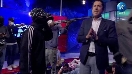 A hooded man points a gun at the TV presenter José Luis Calderón’s head live on air inside the TC Televisión station in Guayaquil on 9 January 2024.