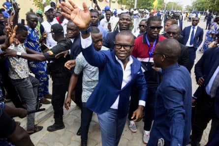 Romuald Wadagni wearing a suit and waving to supporters at an election campaign event