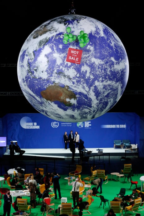 Greenpeace demonstrators raise banner at COP26 globe in final hours of summit.