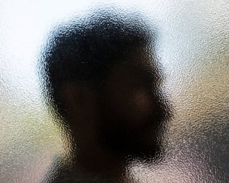The silhouette of a man's head behind frosted glass