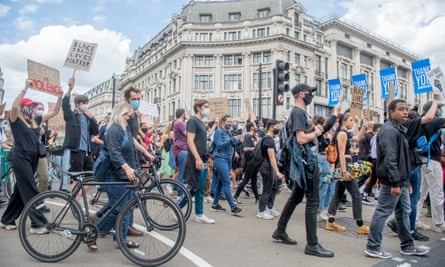 Supporters of the Black Lives Matter movement carry banners and march along Oxford Street, London, on 21 June.