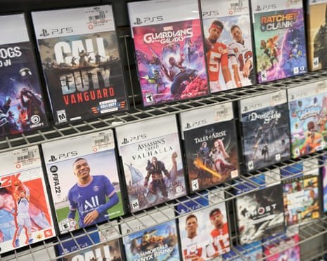 PS5 game cases displayed on wire shelving in a GameStop store