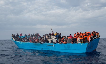 Refugees and migrants put on life jackets distributed by rescue crews off Lampedusa last week.