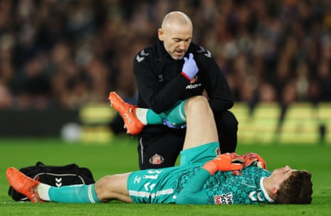 Sunderland's keeper Melker Ellborg receives medical attention after sustaining an injury.