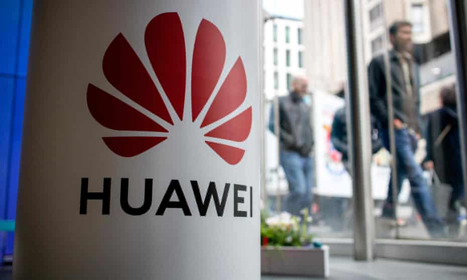 Huawei sign on pillar with pedestrians in background
