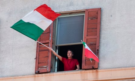 A resident waves the Italian flags in the Garbatella district of Rome on April 25, 2020