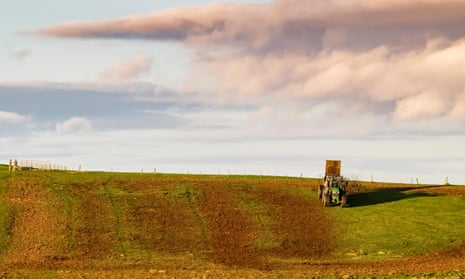 A farmer spreads manure over a field in the Scottish Borders