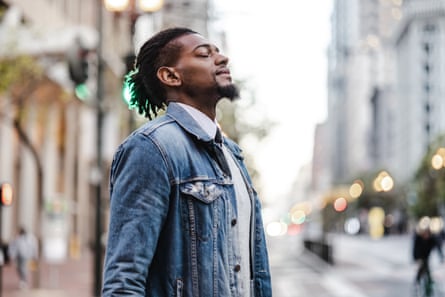 Man with his eyes closed stands in the streetPosed by model Young African-American man taking deep breath on the street