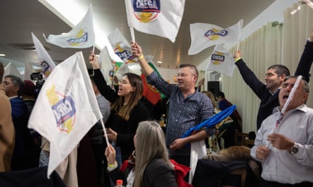 Supporters of the Chega party wave flags at a dinner event in Mouços, Vila Real, Portugal, February 2024.