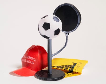 a microphone with a football on top next to a red MAGA cap