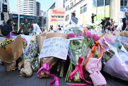 People pay their respect and lay flowers at the scene of the Bondi Junction attack