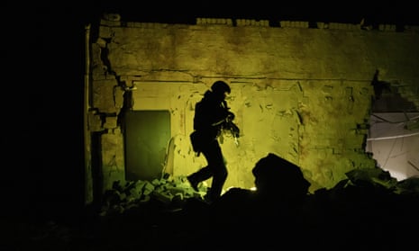 A Ukrainian special police officer patrols during night curfew in Kharkiv.