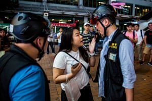 A police officer argues with a women after clashes with anti-government protesters in the Kwai Fong district of Hong Kong.