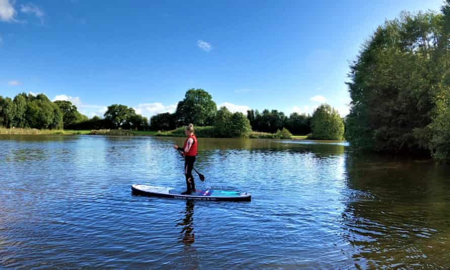 A woman paddleboards on Alderford Lake