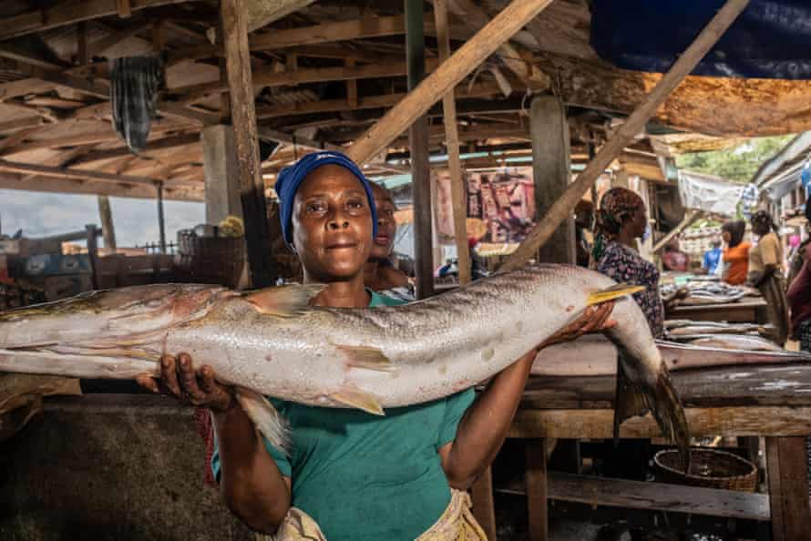 Mrs Abdullahi holds a ample  ‘Barakuta’ fish. She followed her parent  into moving   astatine  the market