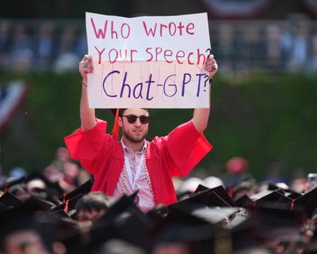 A student holds up a sign reading 'Who wrote your speech? ChatGPT?'