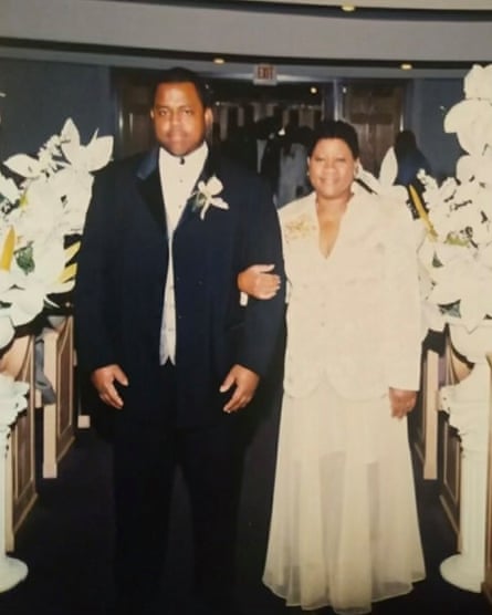 A man in a black tuxedo and white dress shirt with his mother, who is wearing white