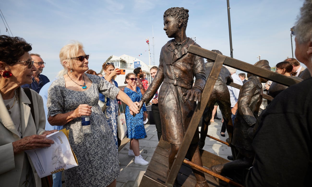 One of the Kindertransport survivors touches the memorial statue, Safe Haven, on Harwich quayside at the unveiling ceremony.