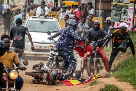 A Ugandan police officer pushes a supporter of opposition leader Bobi Wine, as police try to control crowds during a campaign rally in Mukono on 9 January 2026.