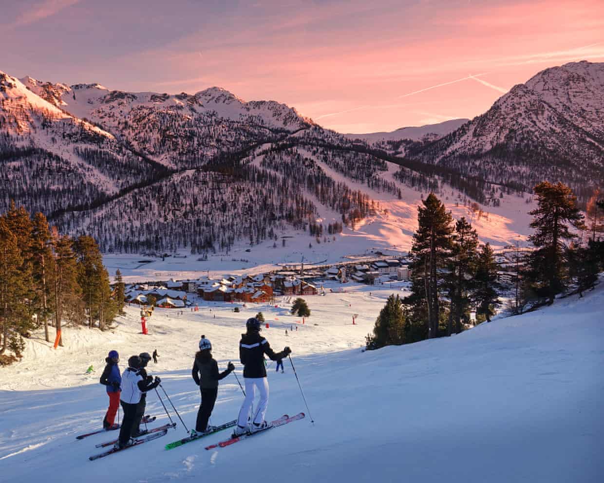 Montgenevre ski resort - four skiers looking at striking pink sunset
