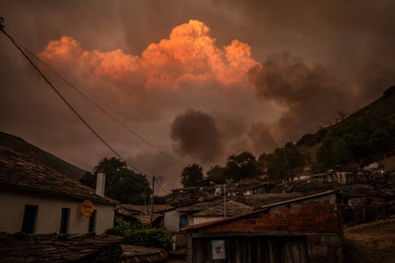 A fiery cloud looms over a village