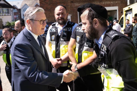 Starmer shakes hands with a volunteer from Shomrim.