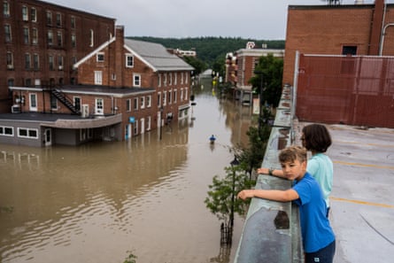 Flooding in a downtown with children watching from an elevated position.