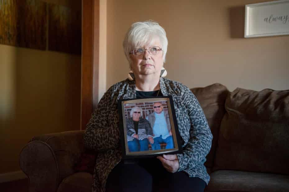 Cindy Anderson poses with a photo of her late husband “Butch” in her home on December 23 in Kennett, Missouri. The city has been without a hospital since the closing of Twin Rivers Regional Medical Center in 2018. Photograph: Brandon Dill for The Guardian