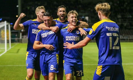 AFC Wimbledon’s Anthony Hartigan (second left) celebrates with teammates after scoring the goal at Northampton that earned a tie at Arsenal.