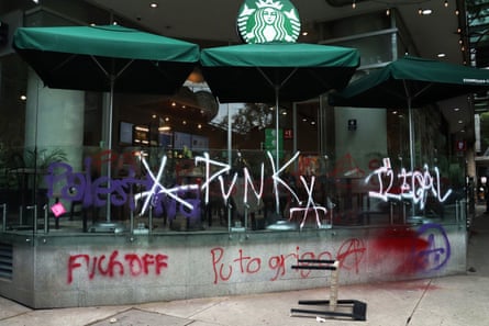 Demonstrators vandalise a Starbucks coffee shop during the protest against gentrification in Mexico City.