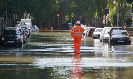 A Thames Water official on a London road after a water main burst, causing flooding in 2022.